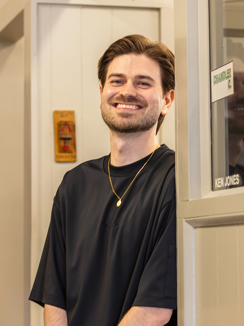 Portrait image of Chandler. A barber at the Quaker Village Barber & Style Shop in Greensboro, NC.