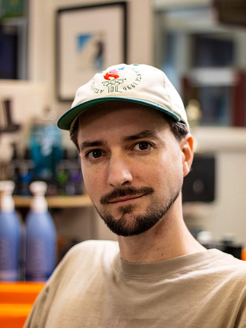 Portrait image of Chris. A barber at the Quaker Village Barber & Style Shop in Greensboro, NC.