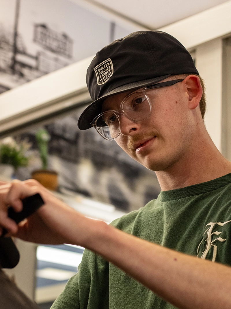 Portrait image of Gavin. A barber at the Quaker Village Barber & Style Shop in Greensboro, NC.
